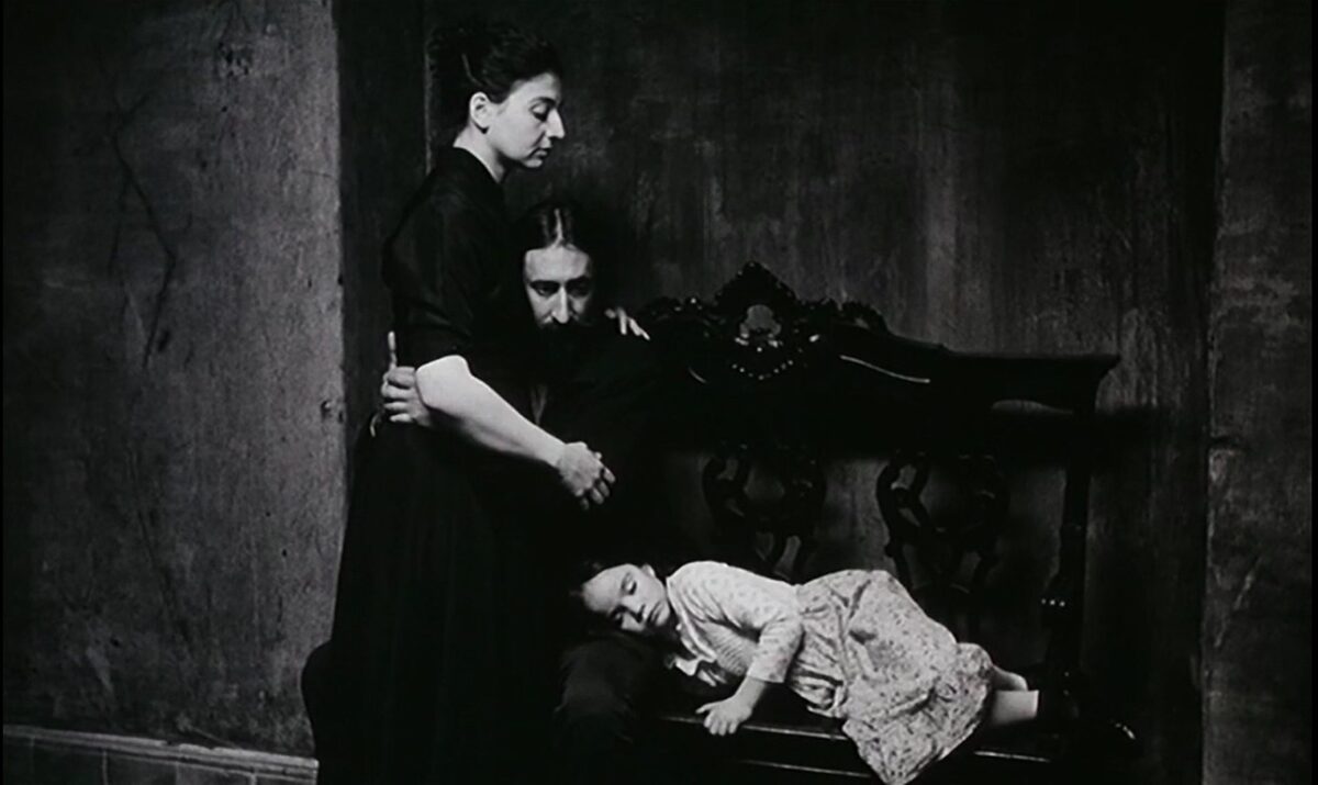 FRÁGIL COMO O MUNDO (2001) de Rita Azevedo Gomes 3 Madre de Vera (Sophia Balabanian). Padre (Carlos Ferrerira). Fotograma con aire de Dreyer. Familia en banco negro. Frágil Como o Mundo. Rita Azevedo. estrellamillansanjuan.es