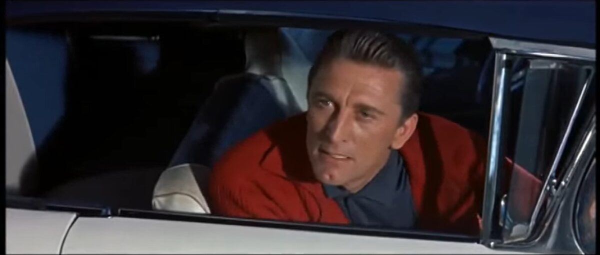 Kirk vestido de rojo insistiendo en una cita. UN EXTRAÑO EN MI VIDA (Strangers When We Meet,1960) de Richard Quine. estrellamillansanjuan.es