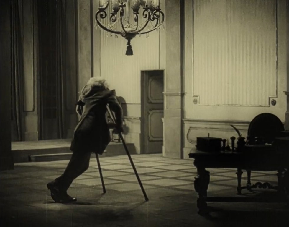 Escena impactante del gobernador en su despacho con sus muletas destacando sobre fondo claro. VANINA (1922). Arthur von Gerlach. estrellamillansanjuan.es