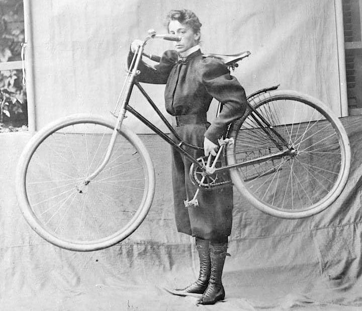 Mujer ciclista vestida con los pantalones bombachos (bloomers) y botas en vez de tacones que le proporcionaron comodidad y menor peligrosidad. Muy criticados por romper las normas.