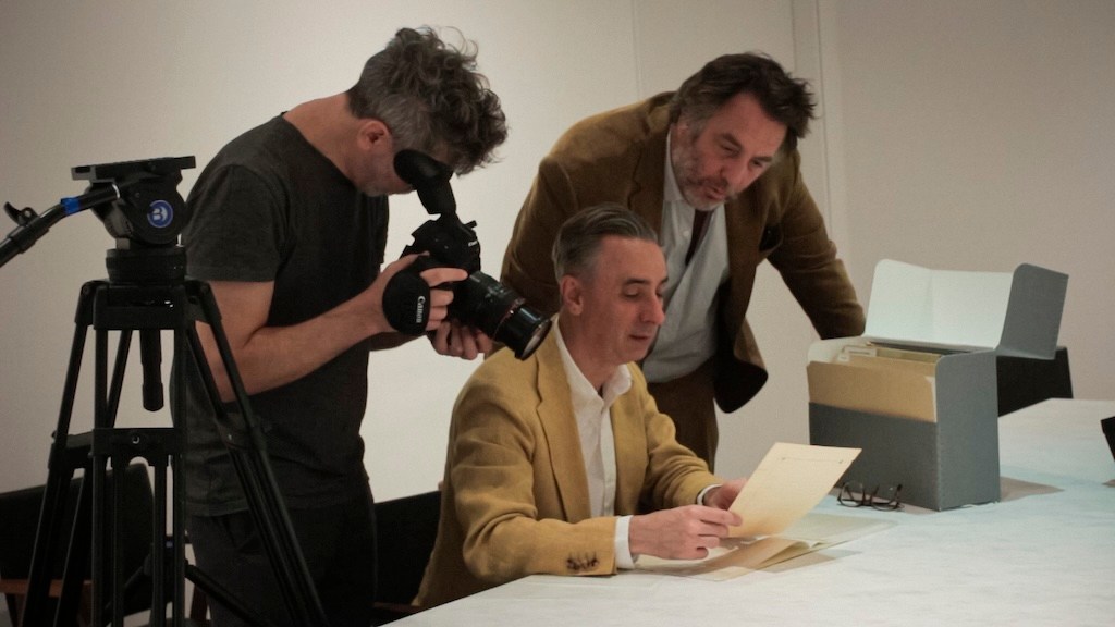 Agustín Mendilaharzu, Erenesto Montequín y Mariano Llinás observando la colección de objetos de Borges. Biografía de Jorge Luis Borges (2026). Mariano Llinás. El Pampero Cine. estrellamillansanjuan.es
